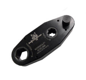 Black climbing belay device with rope attachment holes and carabiner connection point.